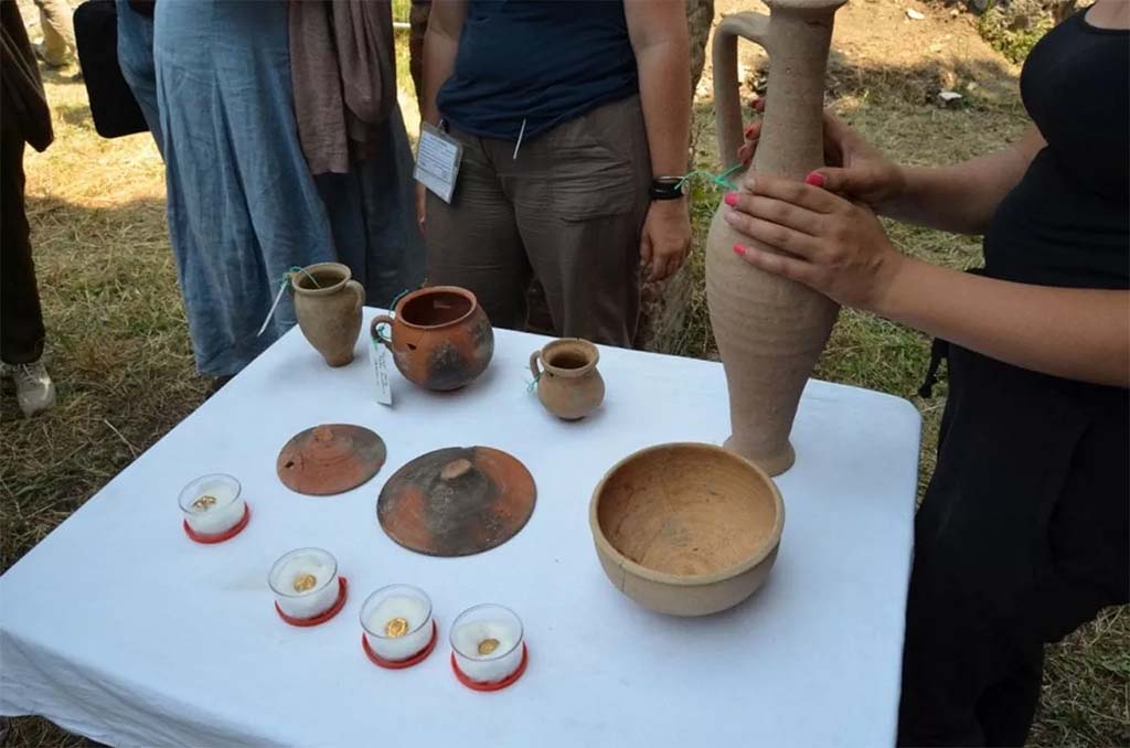 HGE20 Pompeii. June 2016. Alongside the bones, three gold coins, a necklace pendant and some tableware were found.
Accanto alle ossa sono state ritrovate tre monete d’oro, un pendente di collana e alcuni vasi da mensa.
Photograph © Parco Archeologico di Pompei.