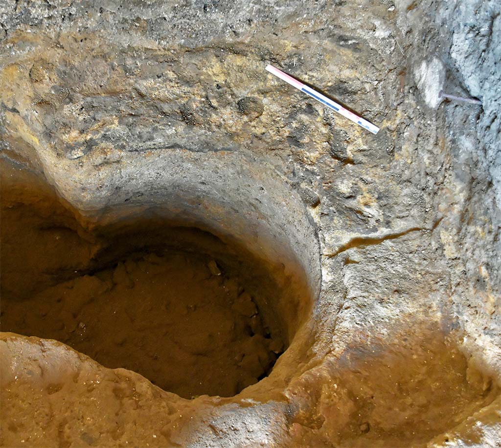 Fig. 20 – Boutique N20. Vestiges de la citerne située au nord-est de la pièce N20/2-3.
On note un des échelons dans la paroi septentrionale.
Vue du sud.
Cliché : N. Monteix-EFR.