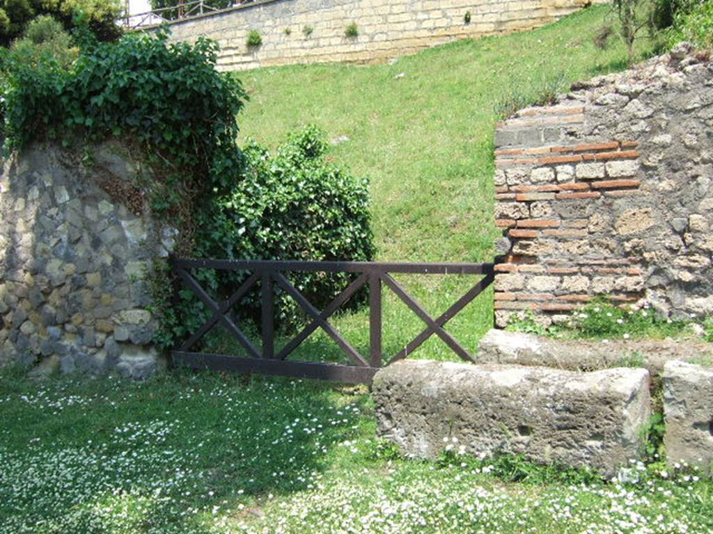 HGE22 Pompeii. May 2006. Looking north-east towards entrance doorway.
According to Garcia y Garcia, on 18th September 1943 a bomb smashed the poor remains of the shops at HGE22, 23, 24 and the colonnade outside them.
The damage was not recorded in the official report, but can be seen in a photo (fig.398 -Foto SAP neg 57-A). See Garcia y Garcia, L., 2006. Danni di guerra a Pompei. Rome: L’Erma di Bretschneider. (p.163)