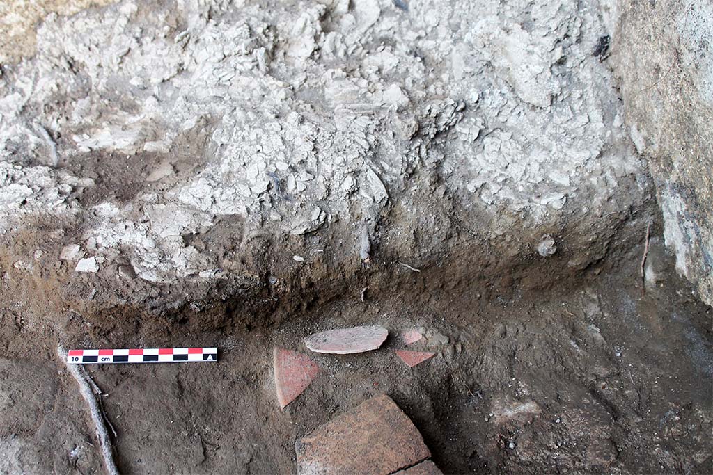 Fig. 18 – Niveau d’interface dans lequel reposaient les vases crus dans l’angle nord-est de la pièce 28.1.
Pris du sud.
L. Cavassa, EFR/CNRS.