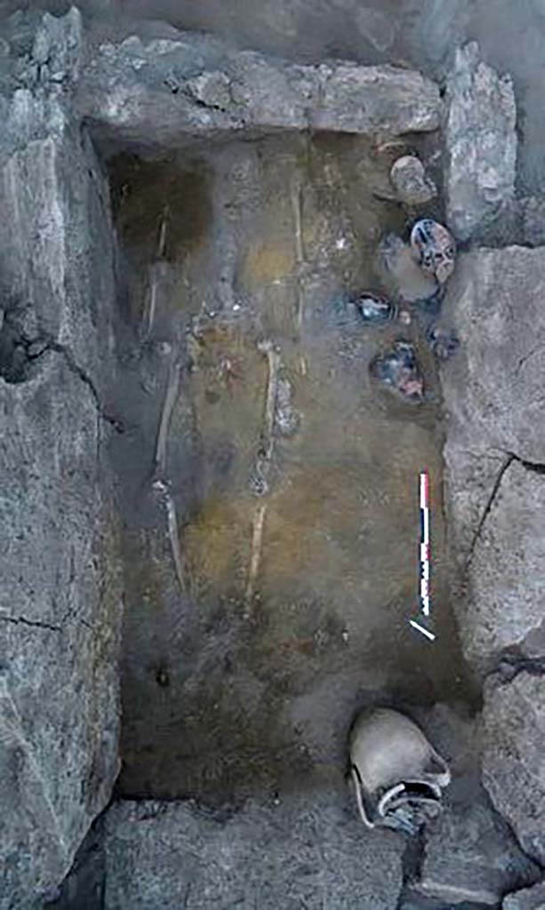 HG31A Pompeii. Tomb of a Samnite Woman. 2015.
The tomb contained the skeleton of a woman lying on her back, surrounded by twelve red-figure Attica-style vases with red motifs on a black background and an amphora.
The head was presented to the north-east.
Photograph © Parco Archeologico di Pompei.