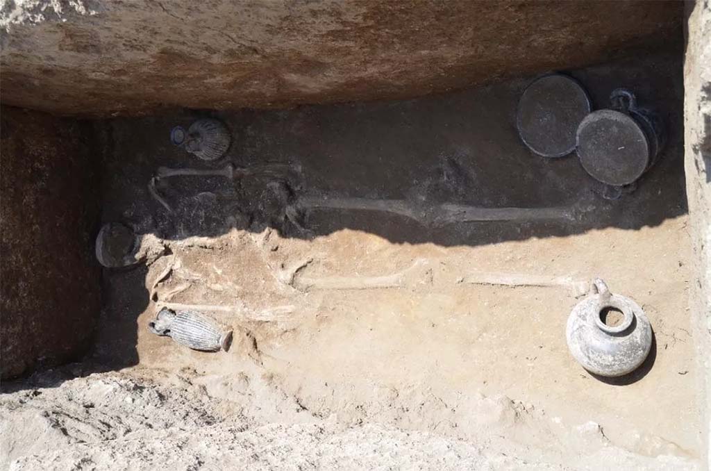 HGE32A Pompeii. June 2016. Tomb of a Samnite Man. The distribution is as follows:
there is an oenochoe lying against the right arm, a lekythos in a vertical position near the left arm, then three vases next to the left leg: a cup on a high foot, a kylix, and a skyphos, while near the right leg, there was a jug.
La répartition est la suivante :
on retrouve une oenochoe en position allongée contre le bras droit, un lécythe en position verticale à proximité du bras gauche, puis trois vases à côté de la jambe gauche : une coupe sur haut pied, une kylix, et un skyphos, tandis qu’à proximité de la jambe droite, se trouvait une cruche.
See Pompéi, Porta Ercolano : organisation, gestion et transformations d’une zone suburbaine: Campagne 2016 CEFR 1676 and below.
Photograph © Parco Archeologico di Pompei.
