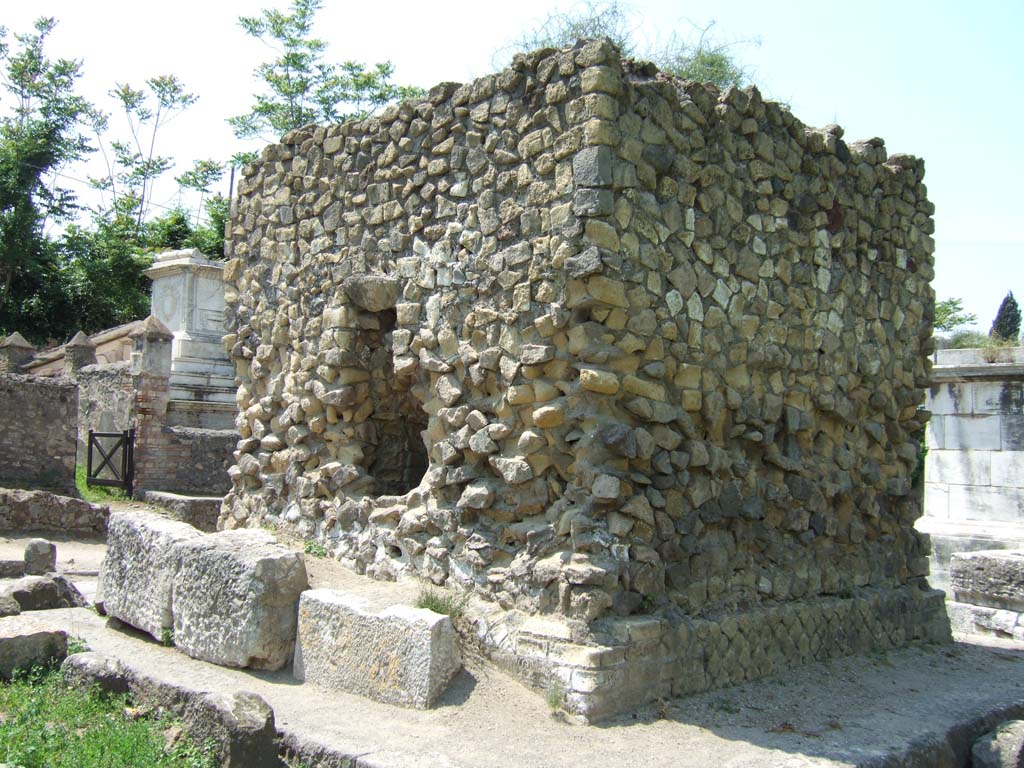 HGE34 Pompeii. May 2006. South side with window, and east side.  
According to Garcia y Garcia, a bomb fell onto the roadway near to the tomb with the marble door.
This caused the partial disintegration of the bed of the road, with the breaking up and loss of five irregular blocks of the lava-stone.
See Garcia y Garcia, L., 2006. Danni di guerra a Pompei. Rome: L’Erma di Bretschneider. (p.165)
