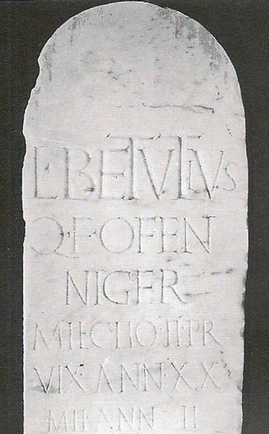 Tomb NG1 Pompeii. Tomb of praetorian Lucius Betutius Niger, son of Quintus.
The inscription was on a marble slab with a rounded top, fixed in the ground, where a terracotta lidded jar containing the remains of the cremation was buried.
Next to this were the remains of the funeral pyre, including fragments of decorative bone, perhaps from a funerary couch.
L(ucius) BETVTIVS
Q(uinti) F(ilius) O(u)FEN(tina)
NIGER
MIL(es) C(o)HO(rtis) II PR(aetoriae)
VIX(it) ANN(is) XX
MIL(itavit) ANN(is) II
Cooley translates this as
Lucius Betutius Niger, son of Quintus, of the Oufentinan tribe, soldier in the 2nd praetorian cohort.
Lived for 20 years, performed military service for 2 years.
See Cooley, A. and M.G.L., 2004. Pompeii : A Sourcebook. London : Routledge. G66, p. 156.
See De Caro, 1979, Cronache Pompeiana V, pp. 86-93
See Stefani G., in SAP, 1998. Pompei Oltre la Vita: Nuove testimonianze dalle necropoli, p. 40.
See De Caro, 1979, Cronache Pompeiana V, pp. 86-93
See Stefani G., in SAP, 1998. Pompei Oltre la Vita: Nuove testimonianze dalle necropoli, p. 40.