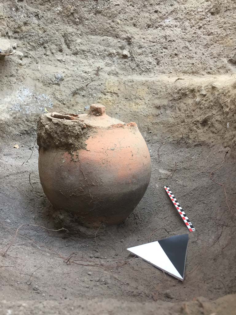 Tomb NG1 Pompeii. August 2017. Immediately behind the tomb, a further cremation urn was discovered.
See Pompeii Porta Nola Necropolis Project in Papers of the British School at Rome: Vol. LXXXVI, 2018, p. 314 and fig.1(a).
Photo courtesy Stephen Kay, British School at Rome.