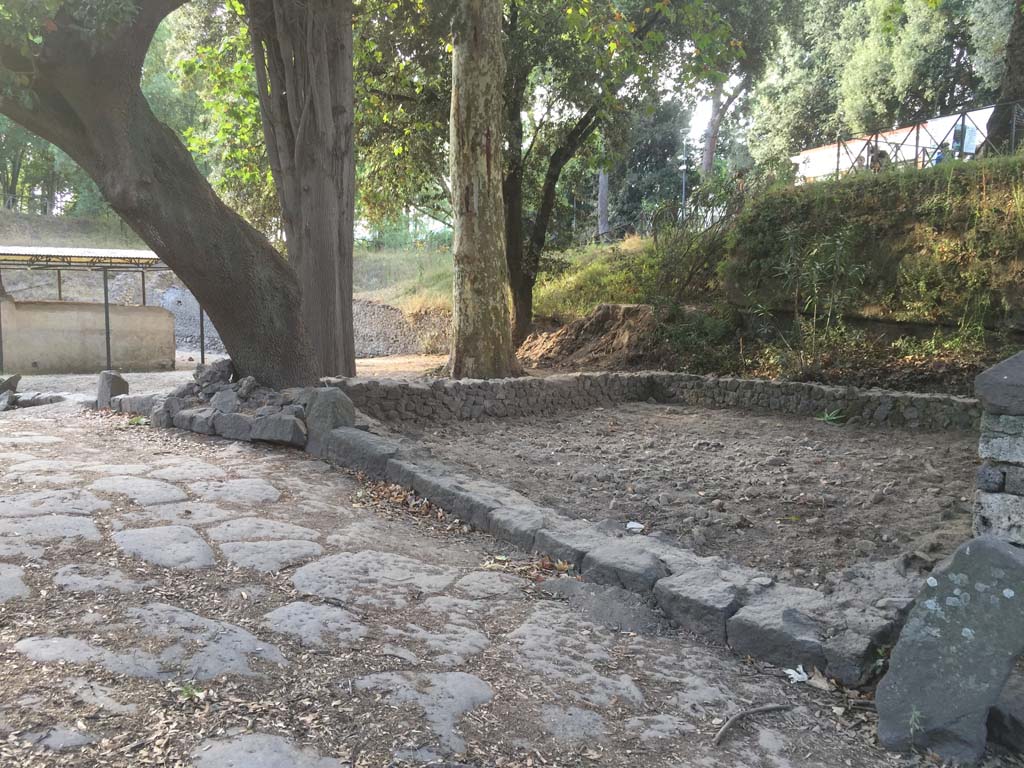 August 2016. Photo courtesy Stephen Kay, British School at Rome.
In 2016 the excavation of a rectangular structure was completed, built just behind the funerary monument of Aesquillia Polla. Variously described by earlier research as a funerary precinct, garden or ustrinum, the 2016 excavation sought to understand the role of this structure, built in a prominent position opposite the Nolan Gate. Once the excavation had removed layers dating to activity of the early twentieth century, which included the burial of a dog and the loss of several terracotta smoking pipes, the work revealed large deposits of construction material used to raise the level beneath the building. However, the 2016 excavation did not record any cremations, supporting the theory of a late construction that was not used before the eruption of AD 79.
See https://britishschoolatrome.wordpress.com/2016/09/08/digging-pompeii-the-2016-summer-excavations/