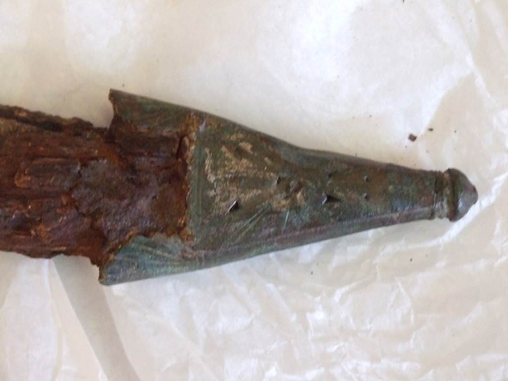Nola Gate Tombs, Pompeii, March 2009.  Detail of bronze sheath tip. SAP inventory number 17047.  
Found with Man no. 5 near Porta Nola in 1976.


