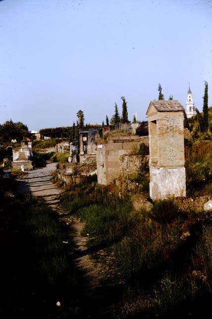 Pompeii Porta Nocera Tomb 23OS. Looking east along Via delle Tombe.
Tomb of Publius Vesonius Phileros, Vesonia and Marcus Orfellius Faustus, on the right. Photographed 1970-79 by Günther Einhorn, picture courtesy of his son Ralf Einhorn.

