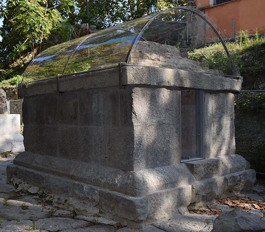 SG5 Pompeii. 2018. Tomb on side facing south away from the Stabian Gate.
The tomb is an almost square shaped structure formed of an elevated foundation of grey tuff parallelepiped blocks, joined together by metallic clamps (at least on the northern side), onto which the roofing was built, consisting of a series of small steps of earth, lava stones, limestone chips and mortar, of which at least the lowest was conserved in situ.
Within the burial chamber, there are niches in three sides of the brick wall.
At the time of the 2001 excavation, two glass cinerary urns with lids were found; the tomb also contained two blown glass doves and a small jug.
See http://pompeiisites.org/en/comunicati/the-tombs-of-the-necropolis-of-porta-stabia/