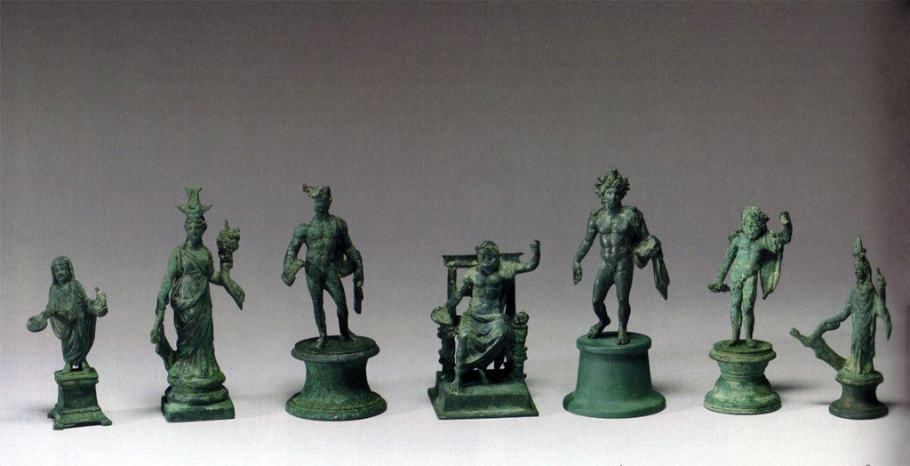 Boscoreale, La villa del Fondo Acunzo. 1903. Room 12.  Podium “y”.
Group of seven bronze statuettes found on podium built against the east wall of the room which opened off the kitchen 8. 
Left to right: Genius familiaris, large Isis Fortuna, Mercury, seated Jupiter, Helios, standing Jupiter, small Isis Fortuna.
Now in The Walters Art Museum, Baltimore.


