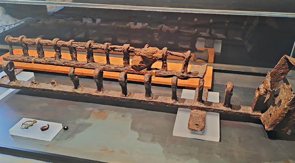 Villa of Agrippa Postumus Boscotrecase. March 2024.
Rear. Iron slave shackle from Villa of Agrippa Posthumus, Boscotrecase.
On display in exhibition in the Palaestra entitled – “L’altra Pompei, vite comuni all’ombra del Vesuvio”.
Photo courtesy of Giuseppe Ciaramella.
