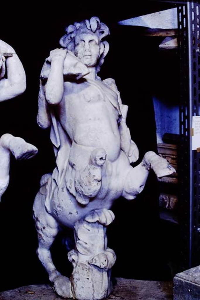 Oplontis Villa of Poppea, 1977. One of a group of four centaurs, a female holding a club and a fawn on her shoulder. 
Two centaur fountains had been on each side of the passageway.
There was no evidence of pipes, so they had not been used as fountains in their final location.
Photo by Stanley A. Jashemski.
SAP{ inventory number 70071.
Source: The Wilhelmina and Stanley A. Jashemski archive in the University of Maryland Library, Special Collections (See collection page) and made available under the Creative Commons Attribution-Non Commercial License v.4. See Licence and use details.
J77f0339
According to De Caro, a group of four centaurs were found under portico 33 on 17th February 1970. 
When they were found, they were very badly damaged. Heads and limbs were mostly detached and it was necessary to provide patient and pain-staking work of re-composition. 
See De Caro, S.1976. Sculture dalla villa di Poppea in Oplontis (p.198) in Cronache Pompeiane, II, 1976, (p.184-225)
