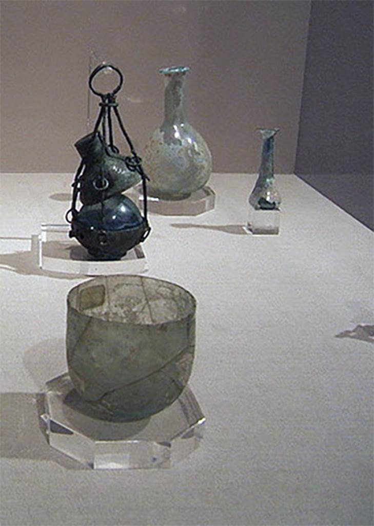 Gragnano, Villa rustica in Località Carmiano, Villa A. Items found in the villa.
Stabiae Antiquarium, inventory numbers
63571 round glass ointment or perfume flask, from near lararium.
63589 tapered glass ointment or perfume flask, from room 3.
63437 bronze hanging perfume holder, from room 1.
61406 glass cup is from Santa Maria La Carità, Villa Petraro.
See Bonifacio G., 2004. In Stabiano: Exploring the Ancient Seaside Villas of the Roman Elite. Castellamare: Nicola Longobardi, p. 132, p. 137.