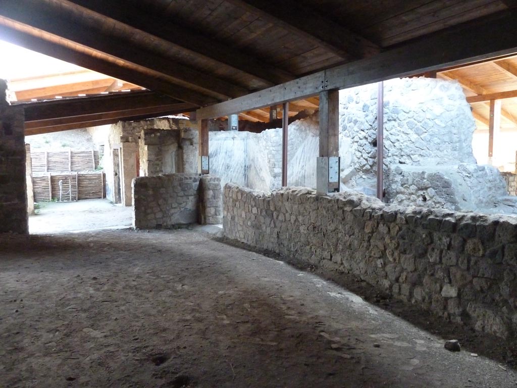 Stabiae, Villa Arianna, September 2015. 
Room 27, looking south-west across room towards doorway to portico, on left, and doorway to corridor 26, centre.
“…. A second incomplete white marble slab was identified near the south corner, 0.60m wide and 0.34m long. This formed part of the access threshold (0.34 x 0.92m) opening onto the service corridor (26)…….. Here, as with the inner side of the threshold, the cleaning work also led to the identification of a second mosaic fragment (0.06 x 0.21m) consisting entirely of black coloured tesserae set horizontally.”
See Gardelli, P., and Ariano, C. Two lesser-known mosaic floors from the 18th Century excavations of Villa Arianna at Stabia. (p.135).



