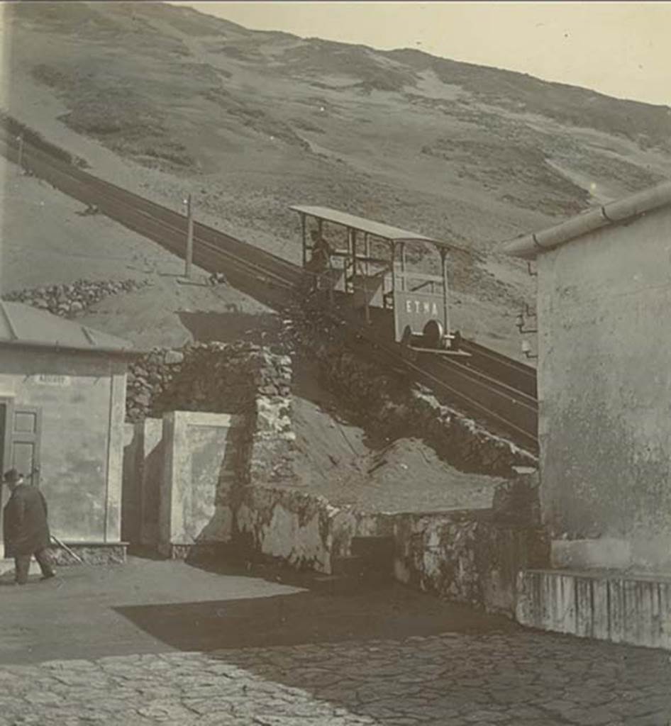 Postcard showing a Wagon of the Vesuvius Funicular, with handwritten note on rear-  “The 1904 Funicular only lasted 2 years”.  
Photo courtesy of Rick Bauer.
This photo must be dated between 1904 when the cars were introduced and 1906 when they were destroyed..
The funicular was modernised at the same time as Cook’s Pugliano to Vesuvius light railway was opened in 1904.
The monorails had been removed and the track was now a one metre gauge single track with a central passing loop.
These cars were new in 1904 and seated 18 with 6 standing. 
Thomas Cook and Son’s name is on the upper part of the structure. The wording on each of the three doors is “Posti 6” (6 places).
Two years later, in a tremendous eruption, on 7 and 8 April 1906 the lower and upper station, the equipment, the machinery, the two funicular cars were destroyed.
Everything was buried under a 20-30m high ash blanket.
Although the light railway as far as the hotel Eremo was quickly dug out, the funicular had to wait. 
Only in 1909, according to the project of the engineer Enrico Treiber, were the works for a new funicular ended and it reopened in 1910.
