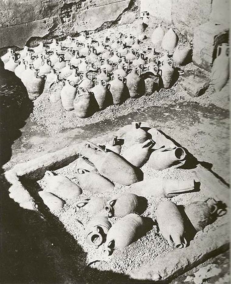I.9.12 Pompeii. Photo taken in 1952. Looking west across the impluvium at amphorae found in atrium.
