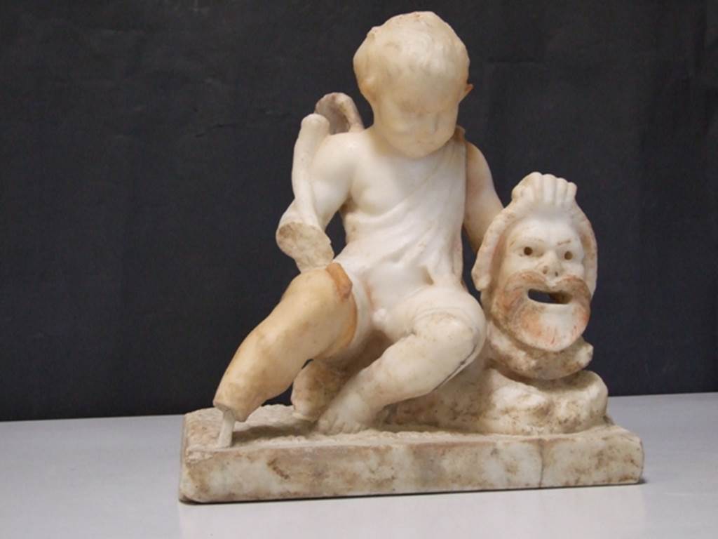 II.2.2 Pompeii. March 2009. Room “l”, garden. White marble statuette of a cupid with a mask.
Found above the marble steps in the nymphaeum at the top of the lower euripus in the garden in 1920.
SAP inventory number: 20513.