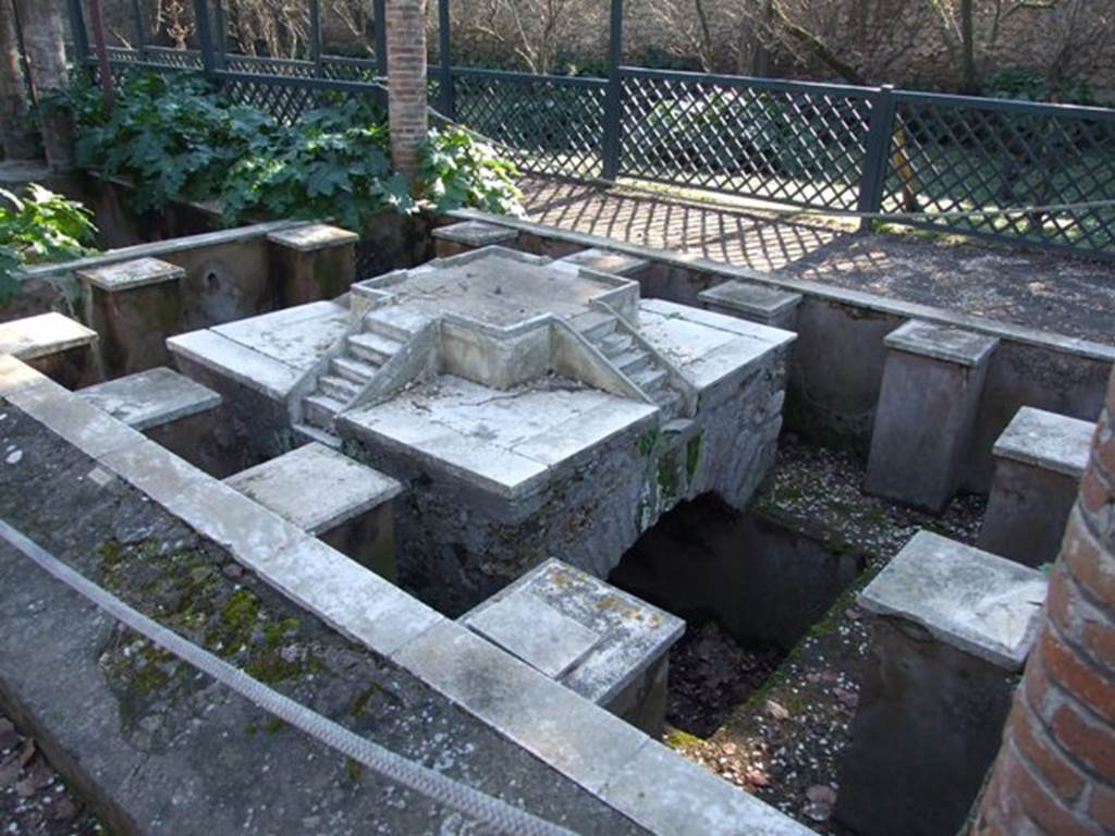 II.2.2 Pompeii. March 2009. Room “l”, garden. Pool and fountain shaded by pergola.
Looking south-west from north end. The fountain has four sets of marble steps on a central platform.
Around the edge are twelve statue or fountain ornament bases.