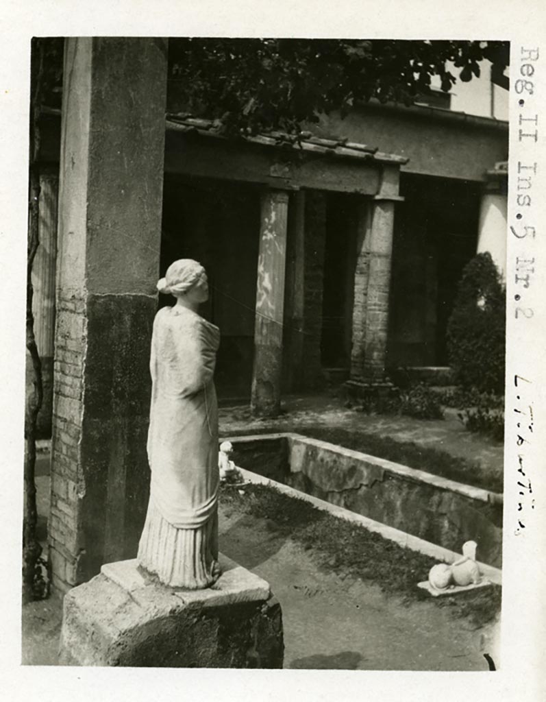 II.2.2 Pompeii, but shown as II.5.2 on photo. Pre-1937-39.
Room “i”, looking north-west towards west end of upper euripus with statue of Muse Erato or Mnemosyne.
The statue of the muse Erato or Mnemosyne and a sphinx (SAP inventory number 2930) are shown.
Photo courtesy of American Academy in Rome, Photographic Archive. Warsher collection no. 1903.
The statue originally stood on one of the six bases along the southern side of the canal, which probably held statues of muses, of which only this and one other have been found. Jashemski describes the two surviving statues as, one of Polyhymnia (SAP 2917) and the second of Mnemosyne (SAP 2909).
The names on her photographs however are reversed.
See Jashemski, W. F., 1993. The Gardens of Pompeii, Volume II: Appendices. New York: Caratzas. (p. 80-1, Figs 84-85).