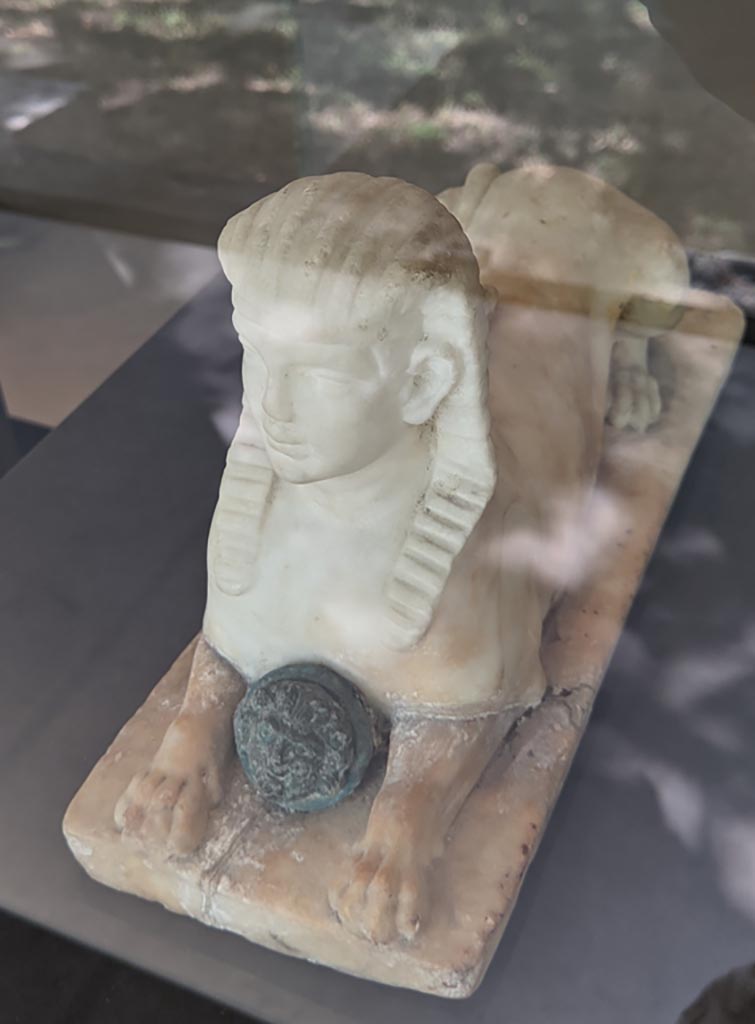 II.2.2 Pompeii. April 2022.
Room “i”, white statuette of Sphinx, found on the north side of the upper euripus, here on display in exhibition in Palaestra.
Photo courtesy of Giuseppe Ciaramella.
