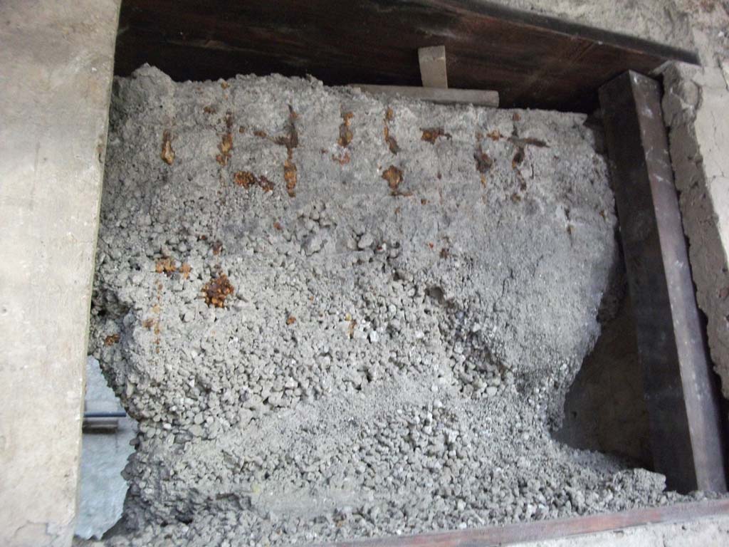 IX.12.9 Pompeii. May 2010. Remains of window grating in north wall of north portico 5b.

